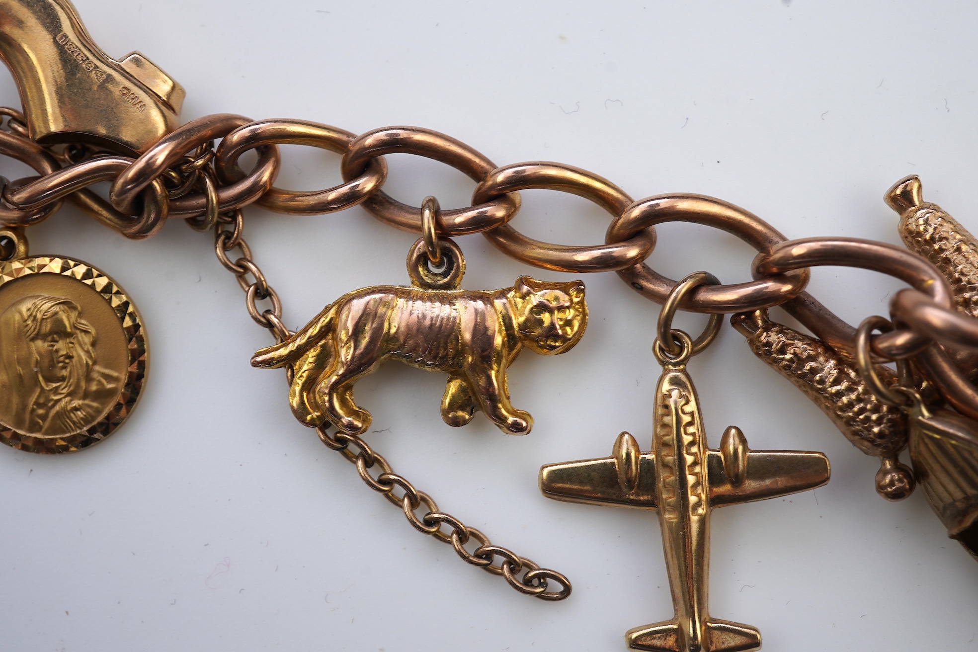 A gold charm bracelet, mid 20th century